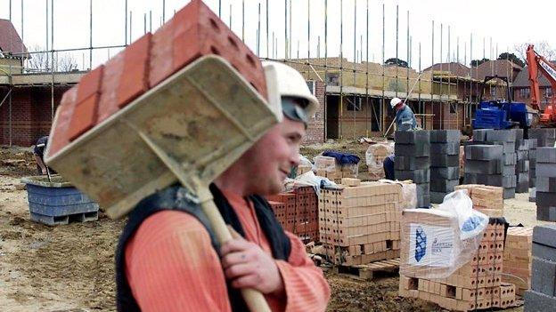 Builder on site carrying hod