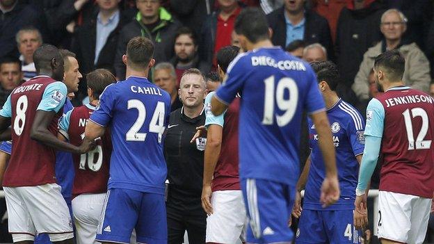 Chelsea and West Ham players surround referee Jonathan Moss