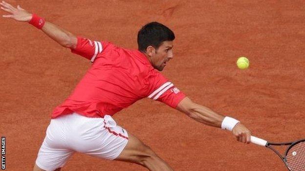 Novak Djokovic stretches for a ball against Ricardas Berankis