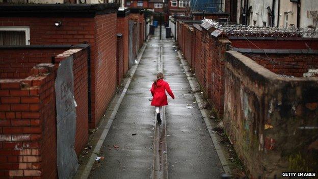 Young girl playing in alleyway in Gorton, Manchester