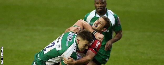 Johnny Williams of London Irish fends off a tackle by Francois Bouvier of Agen