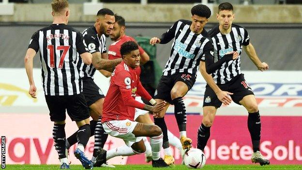 Jamal Lewis tackles Marcus Rashford during a game between Newcastle United and Manchester United in October