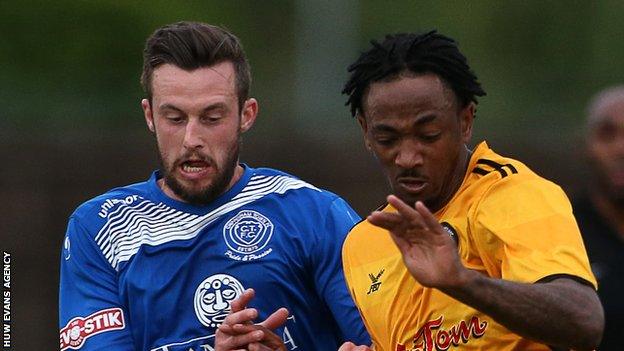 Sanchez Watt of Newport County (R) is tackled by Dan Dowman