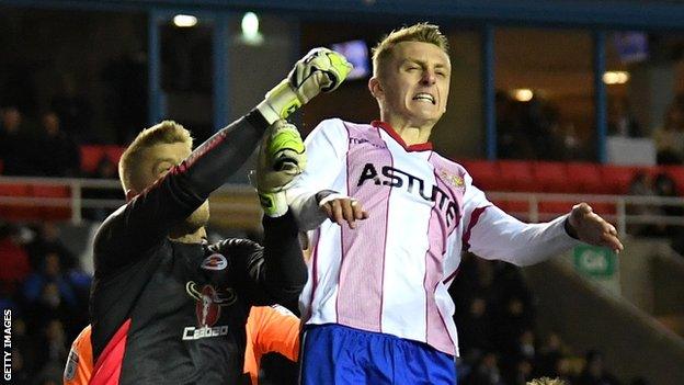 Ben Wilmot (right) challenges for the ball with the opposition goalkeeper