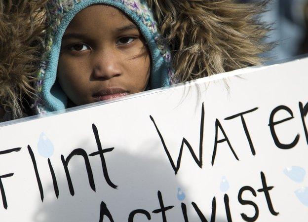 Seanna Dixon, 7, holds a sign during a Selma Solidarity March in Flint, Mich., Sunday, March 5, 2017.