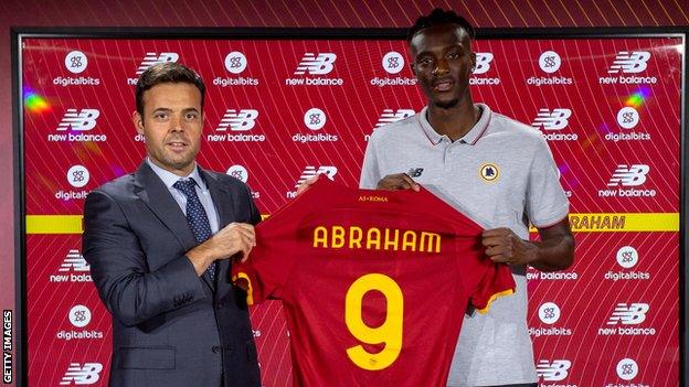 Tammy Abraham holding his new Roma shirt