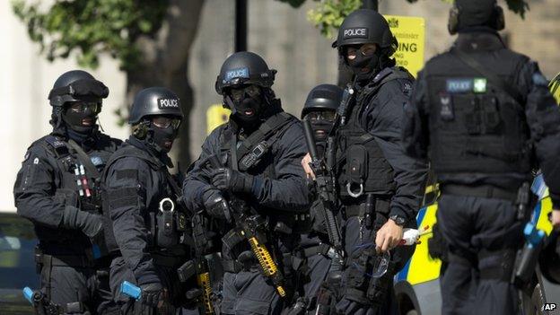 Near the start of a training exercise for London"s emergency services, armed police officers stand near the disused Aldwych underground train station in London