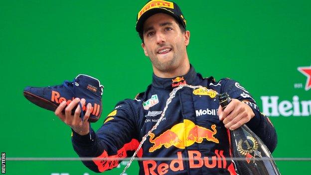 Red Bull driver Daniel Ricciardo goes to pour champagne into his shoe on the podium