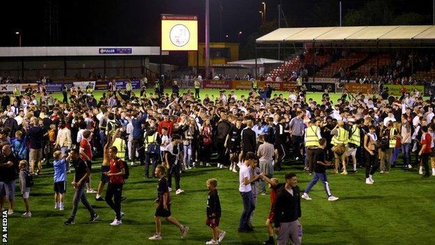 Crawley fans on the pitch following the win over Fulham