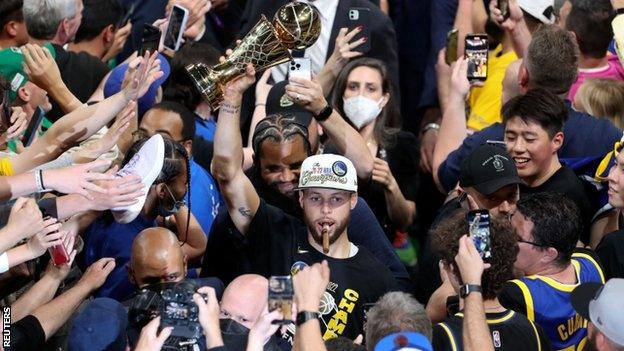 Stephen Curry with the NBA Finals MVP trophy in 2022