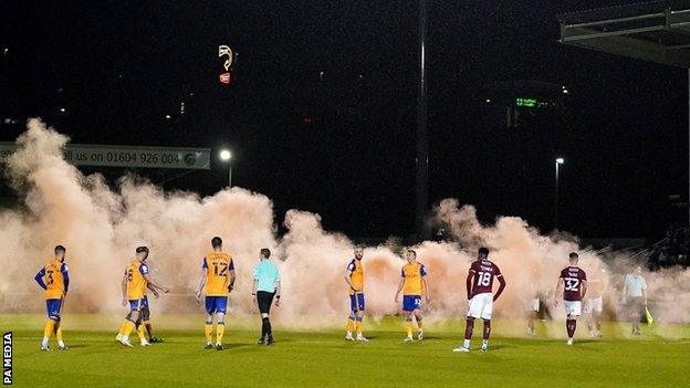 Play at Sixfields was also interrupted by flare smoke