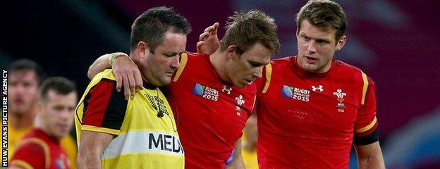 Liam Williams is helped off the field by Dr Geoff Davies