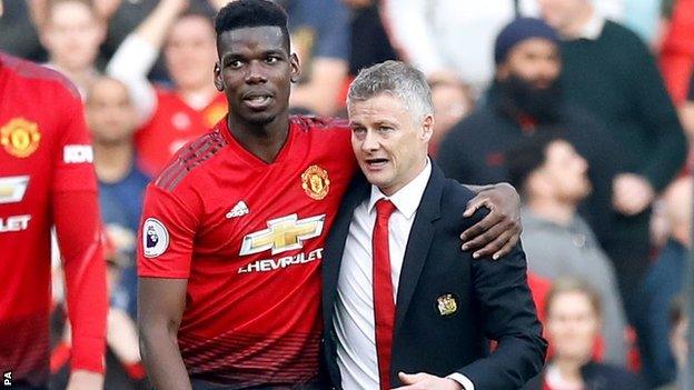 Ole Gunnar Solskjaer and Paul Pogba walk across the pitch at Old Trafford