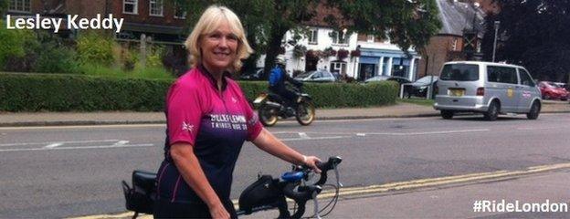 Lesley Keddy on a road, holding her bike