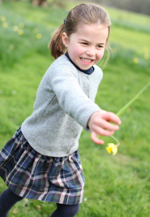 Princess-Charlotte-plays-with-a-flower-in-her-garden.