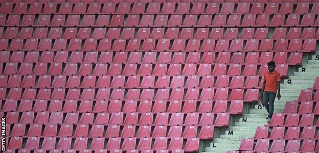 A spectator walks past empty seats in Lucknow as Australia played Sri Lanka