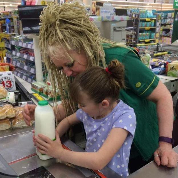 Cashier Lin helps Amanda's daughter to scan the family's shopping