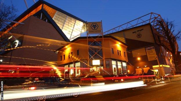 General view of Molineux Stadium at night with traffic driving past