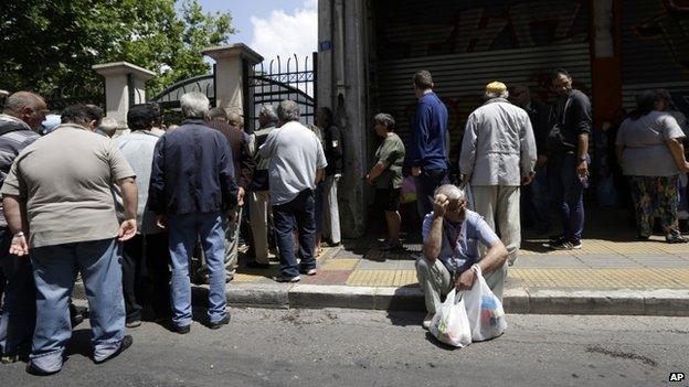 People wait for a soup kitchen to open, organised daily by the municipality in Athens