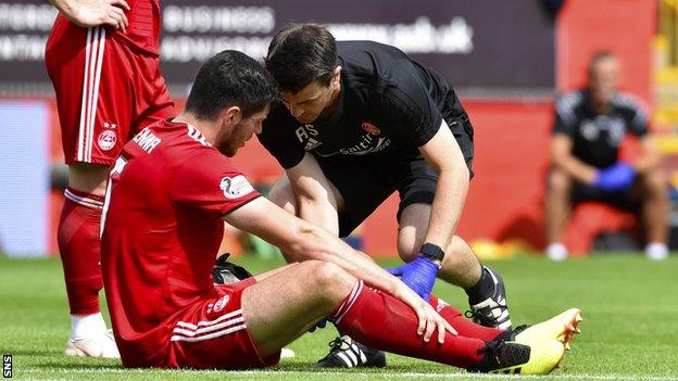 Scott McKenna receives treatment after sustaining a hamstring injury