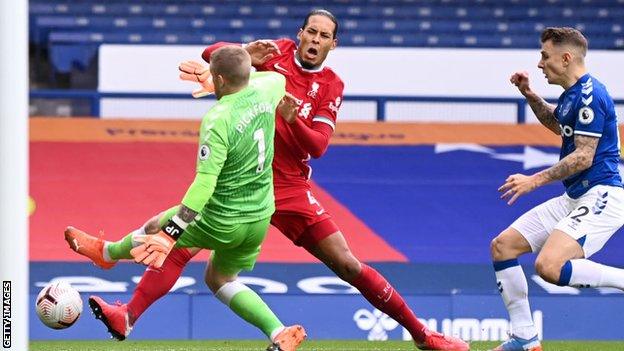 Everton goalkeeper Jordan Pickford takes out Virgil Van Dijk