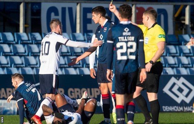 Ross County's Michael Gardyne is booked after a foul on Alfredo Morelos