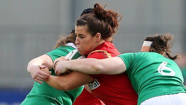 Shona Powell-Hughes of Wales is tackled by Ailis Egan and Paula Fitzpatrick