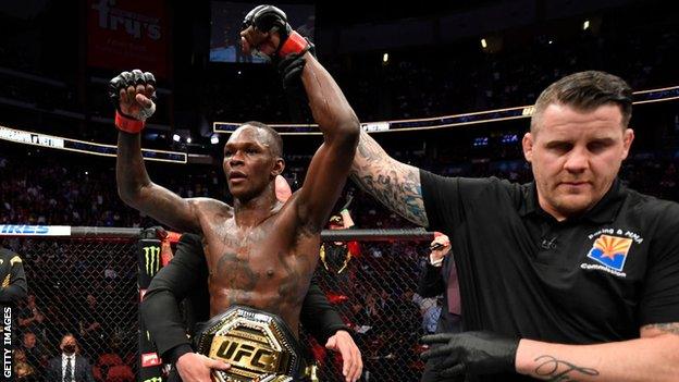 Israel Adesanya celebrates retaining his middleweight title at UFC 263