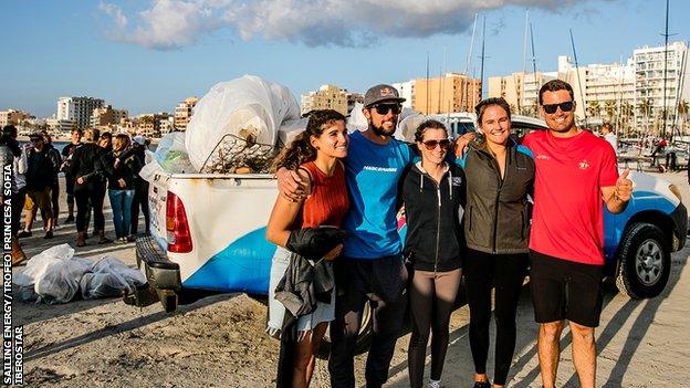 Sailors pose for photoso before beach clean