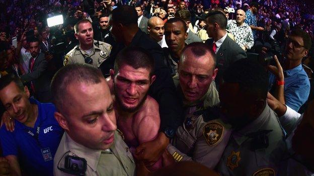 Khabib Nurmagomedov being taken away from the octagon by police