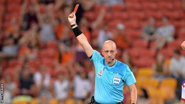 Referee brandishing a red card