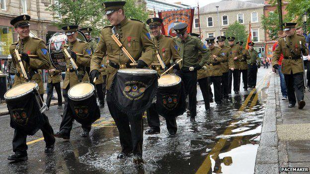 Bandsmen marching through a puddle