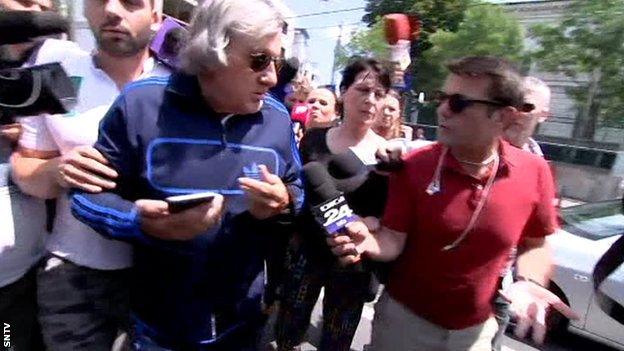 Ilie Nastase surrounded by reporters as he left the police station in Bucharest