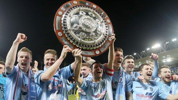 Ballymena players celebrate with the Co Antrim Shield after defeating Linfield in the decider