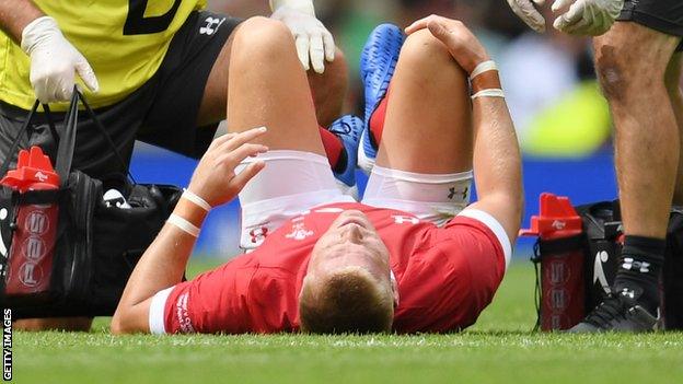 Gareth Anscombe holds his knee in pain at Twickenham