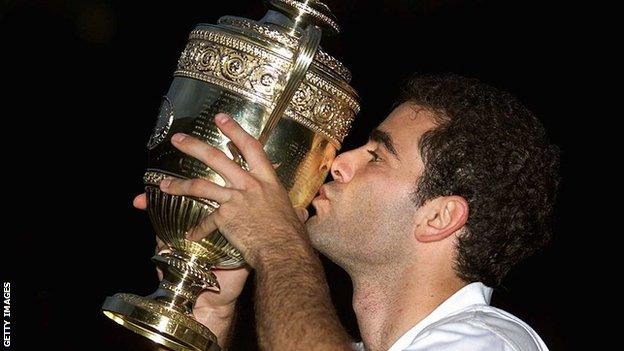 Pete Sampras kisses the Wimbledon trophy in the darkness of Centre Court