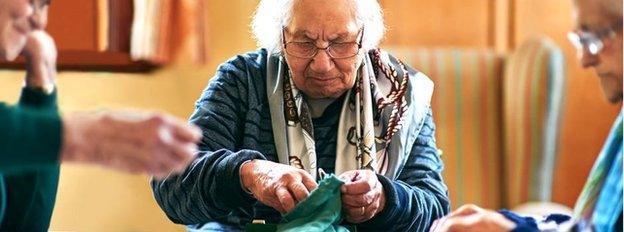 Elderly people, in a care home, play a board game