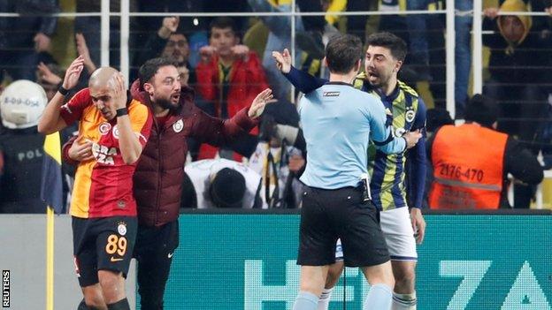 Galatasaray's Sofiane Feghouli takes cover after his side's win at Fenerbahce