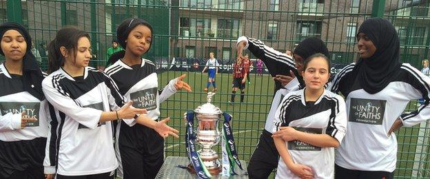 A girls football team pose by the Women's FA Cup