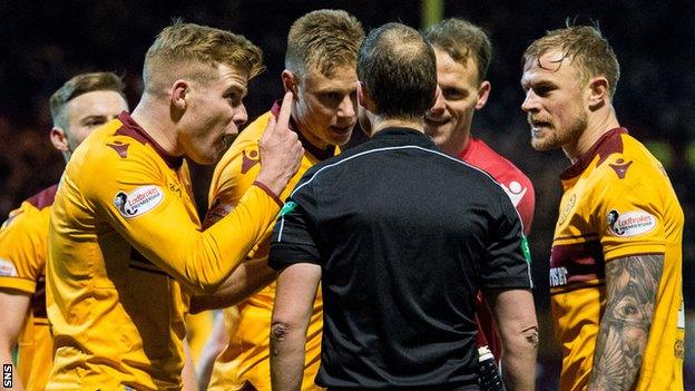 Motherwell players protest referee Willie Collum's decision to award Celtic a late penalty