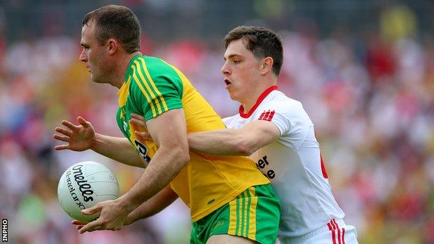 Donegal's Neil McGee shields the ball from Niall Sludden of Tyrone