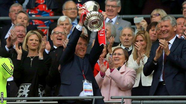 Man Utd manager Louis van Gaal lifts the FA Cup trophy as former Red Devils boss Sir Alex Ferguson joyfully looks on