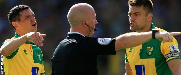 Norwich players remonstrate with referee Simon Hooper