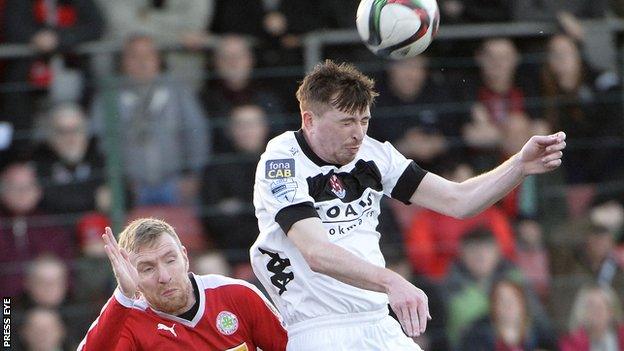 Billy Joe Burns wins an aerial duel with Cliftonville's Chris Curran in Tuesday's game