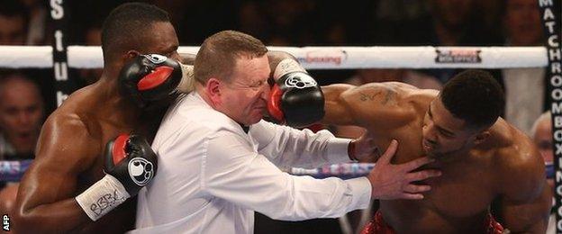 Referee Howard Foster tries to separate Dillian Whyte and Anthony Joshua