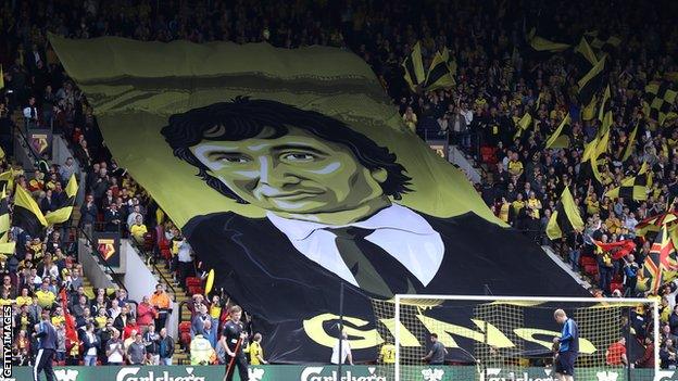 Watford fans fly a flag with the face of owner Gino Pozzo