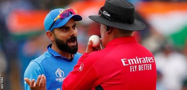 Virat Kohli speaks with an umpire