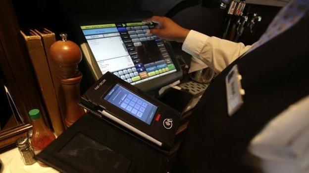 Waitress Courtney Jones processes a dinner tab with a Rail table side credit card processing device at Tableau,