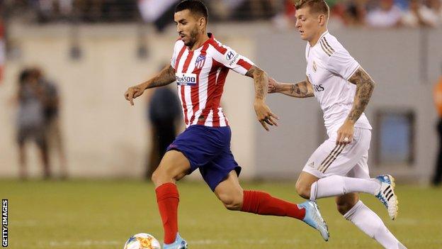 Atletico 's Angel Correa (left) being pursued by Real Madrid midfielder Toni Kroos