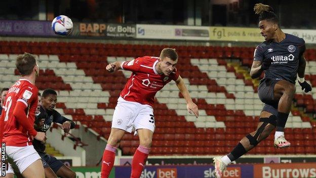 Ivan Toney (far right) heads Brentford ahead against Barnsley